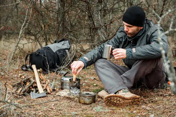Photo of a bushcrafter working on his meal. 
