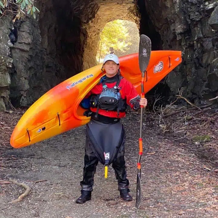 Man ready to paddle with his kayak on the shoulders. 